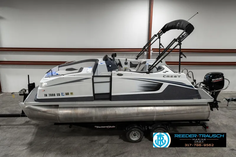 Slide: The Image of 2019 Crest Calypso 190 pontoon boat on trailer in indoor storage. - 1