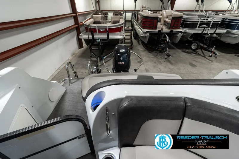Slide: The Image of 2019 Crest Calypso 190 boat interior in showroom with other boats. - 15