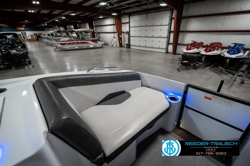 Slide: The Image of 2019 Crest Calypso 190 boat interior in spacious showroom with jet skis. - 21