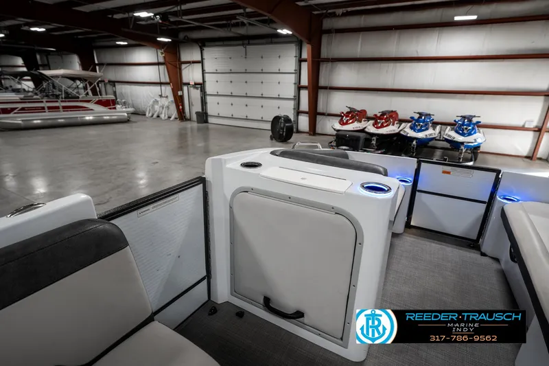 Slide: The Image of 2019 Crest Calypso 190 boat interior in spacious showroom with jet skis. - 25