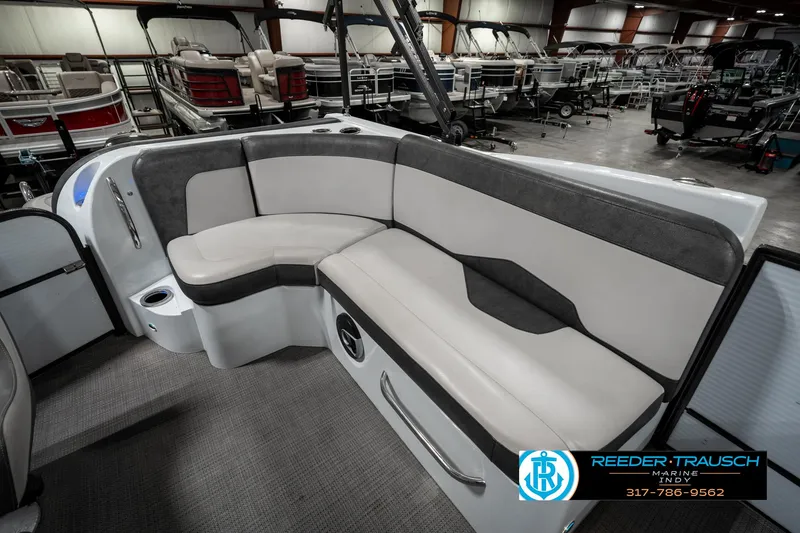 Slide: The Image of 2019 Crest Calypso 190 boat interior with gray and white seating in showroom. - 27