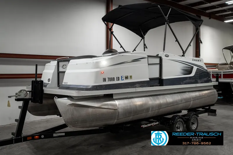 Slide: The Image of 2019 Crest Calypso 190 pontoon boat on trailer in indoor storage. - 3