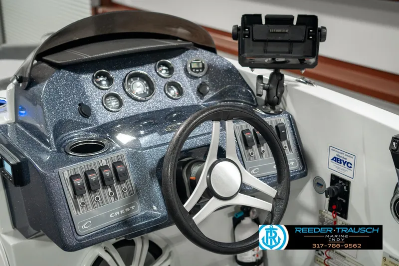 Slide: The Image of 2019 Crest Calypso 190 boat dashboard with steering wheel and control panel. - 32