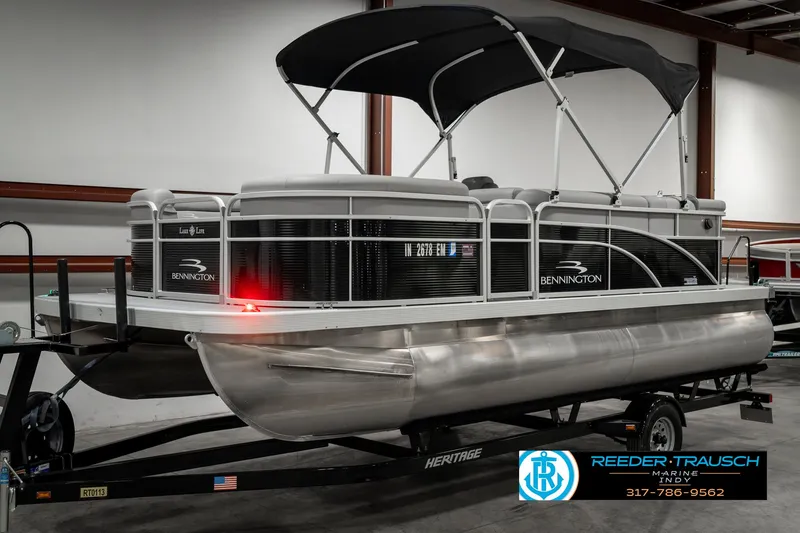 Slide: The Image of 2023 Bennington 20 SVL pontoon boat with canopy on trailer in showroom. - 3