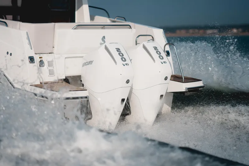 Slide: The Image of 2025 Beneteau Antares 9 with dual Mercury V6 engines cruising through waves. - 12