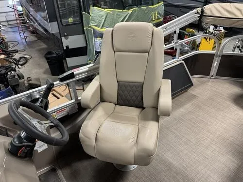 Slide: The Image of 2023 Sun Tracker SportFish 22 XP3 captain's chair and steering wheel in a showroom. - 11