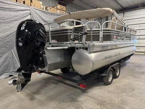 Slide: The Image of 2023 Sun Tracker SportFish 22 XP3 pontoon boat with Mercury outboard motor in a garage. - 3