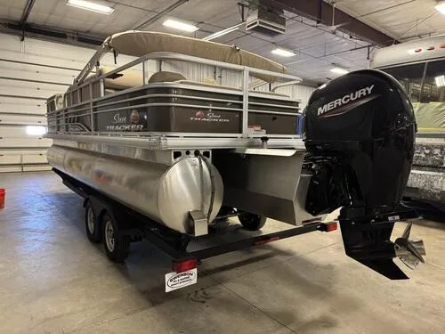 Slide: The Image of 2023 Sun Tracker SportFish 22 XP3 pontoon boat with Mercury outboard motor in a garage. - 4