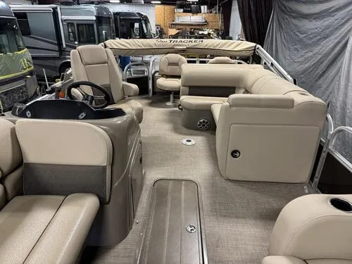 Slide: The Image of 2023 Sun Tracker SportFish 22 XP3 pontoon boat interior with beige seating and steering console. - 6
