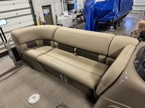Slide: The Image of 2023 Sun Tracker SportFish 22 XP3 boat interior with beige seating in a garage. - 9