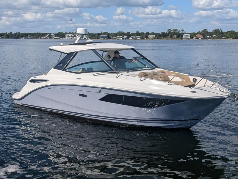 The Image of 2019 Sea Ray Sundancer 320 cruising on a calm lake under a partly cloudy sky. - 1