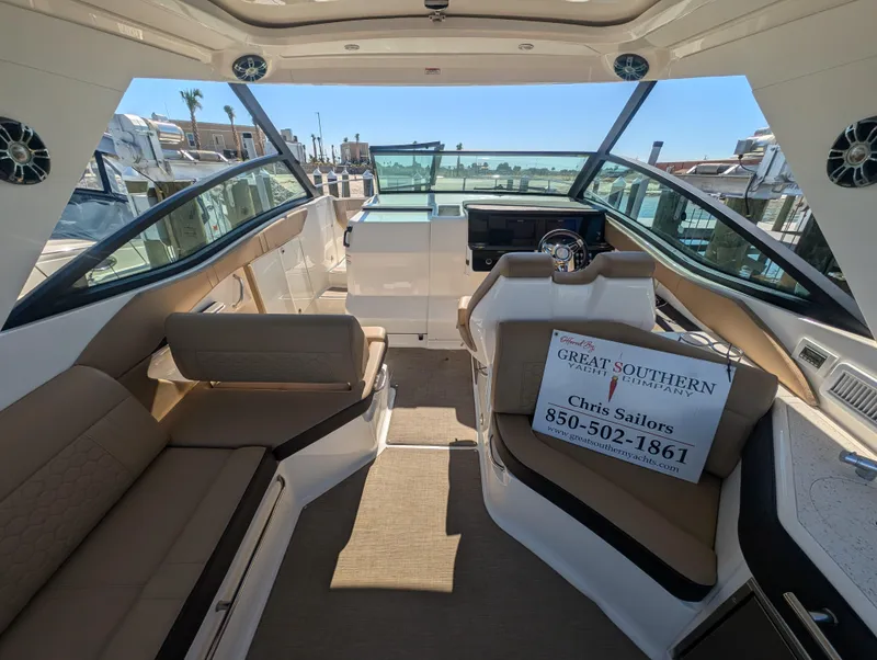 Slide: The Image of 2019 Sea Ray Sundancer 320 interior with seating and helm, docked at marina. - 10
