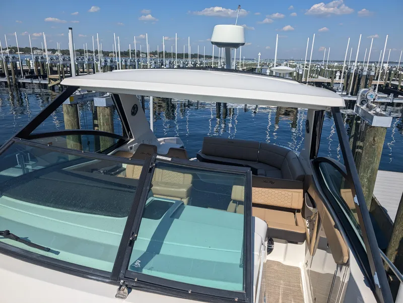 Slide: The Image of 2019 Sea Ray Sundancer 320 docked at marina, clear skies, calm water. - 13