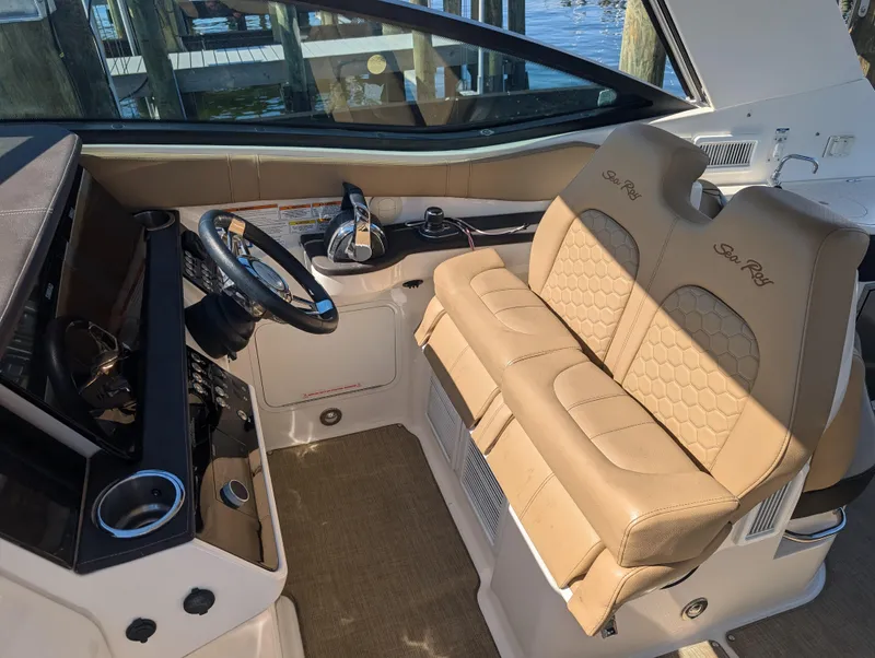 Slide: The Image of 2019 Sea Ray Sundancer 320 cockpit with beige leather seats and modern controls. - 16