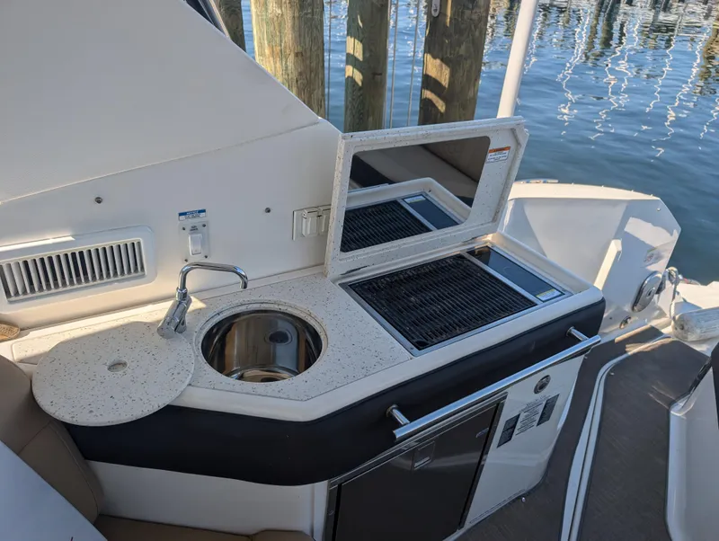 Slide: The Image of 2019 Sea Ray Sundancer 320 boat kitchenette with sink and grill by the water. - 5