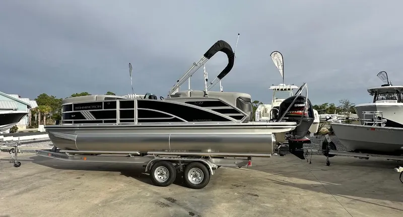 Slide: The Image of 2025 Bennington 22MFB Quad Bench pontoon boat on trailer, outdoor display. - 2