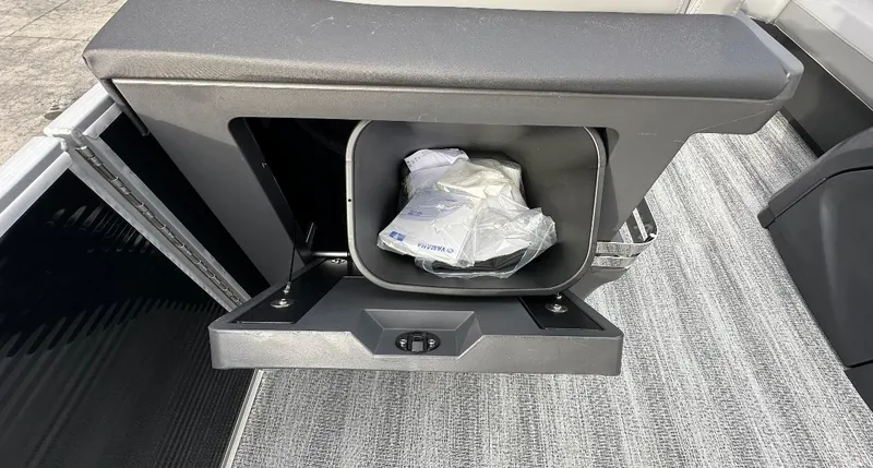 Slide: The Image of 2025 Bennington 22MFB Quad Bench storage compartment with open lid and contents inside. - 7