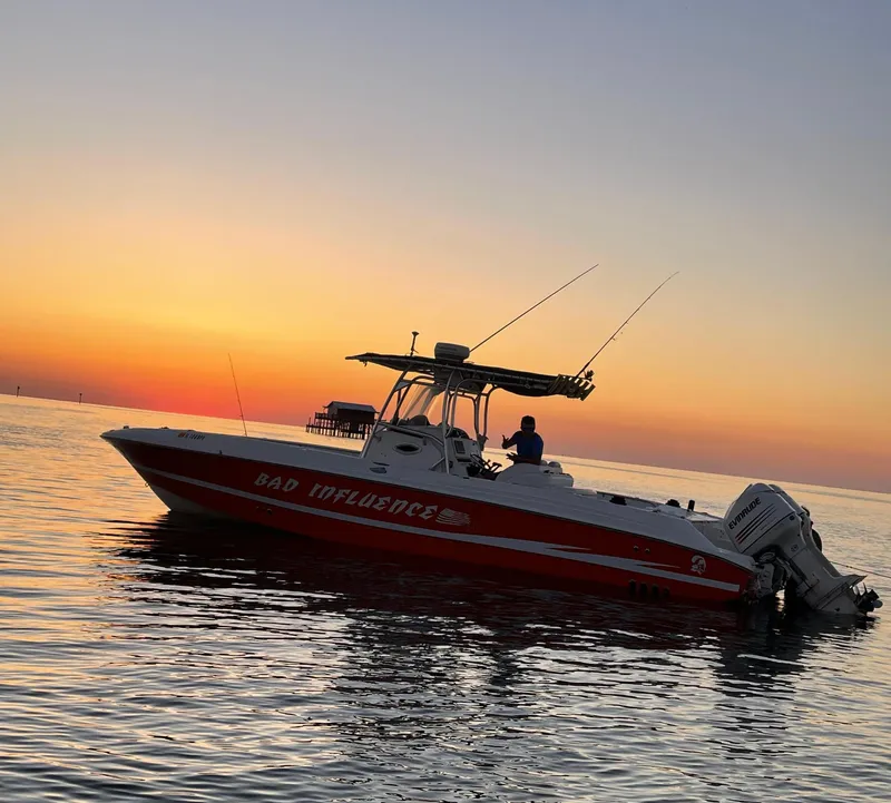 Slide: The Image of 2002 Wellcraft 32 Scarab Sport boat at sunset on calm water. - 2
