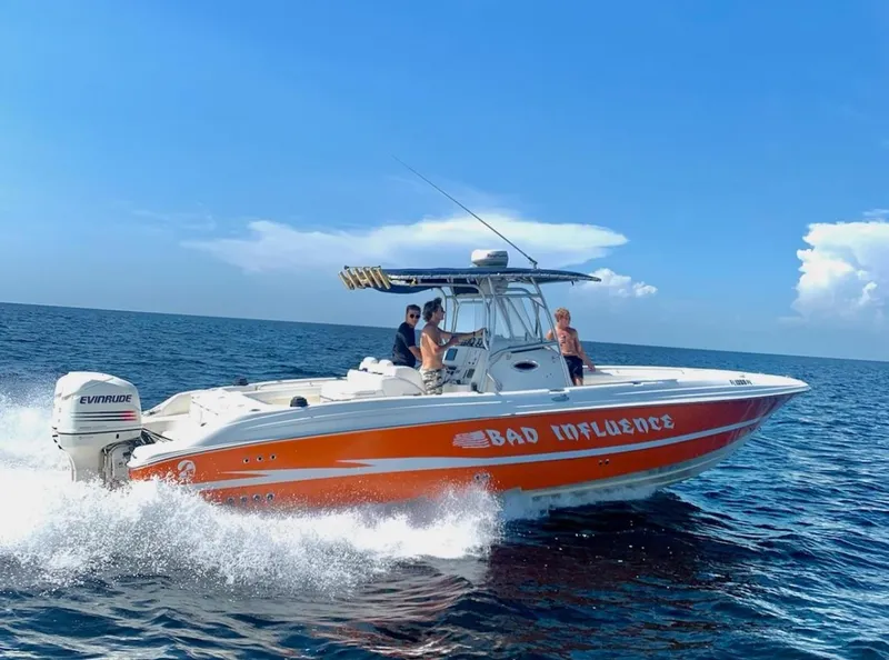 Slide: The Image of 2002 Wellcraft 32 Scarab Sport boat cruising on open water, named "Bad Influence." - 3