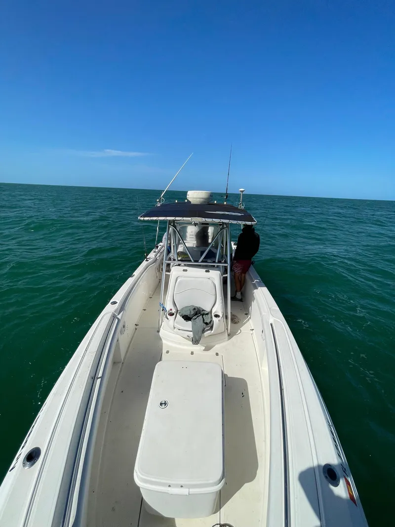 Slide: The Image of 2002 Wellcraft 32 Scarab Sport boat on open water under clear blue sky. - 5