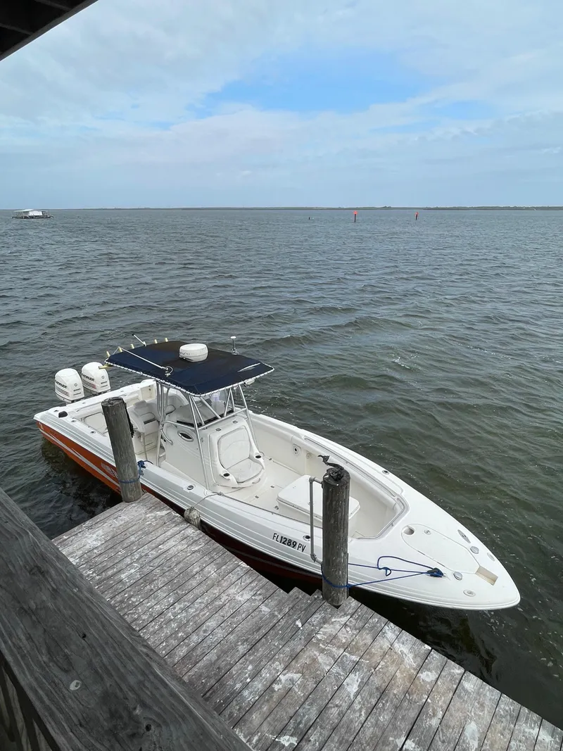 Slide: The Image of 2002 Wellcraft 32 Scarab Sport boat docked by the water. - 6