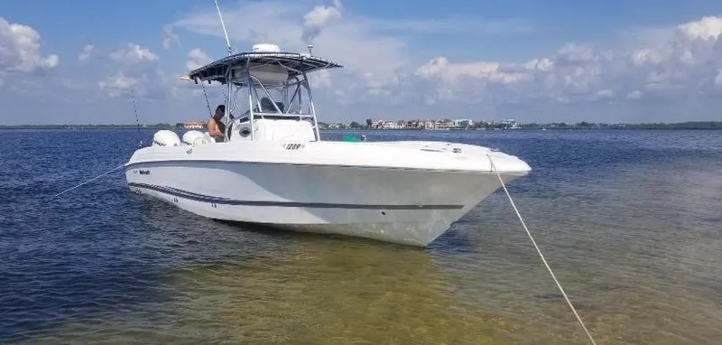 Slide: The Image of 2002 Wellcraft 32 Scarab Sport boat anchored in shallow water on a sunny day. - 8