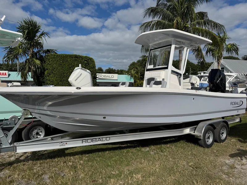 The Image of 2024 Robalo 246 Cayman boat on trailer, palm trees in background. - 1
