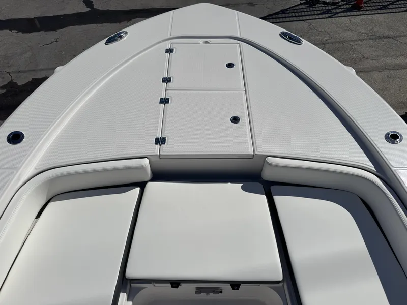 Slide: The Image of 2024 Robalo 246 Cayman boat deck with cushioned seating and storage compartments. - 11