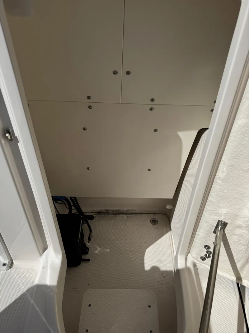 Slide: The Image of 2024 Robalo 246 Cayman interior cabin with storage compartments. - 17