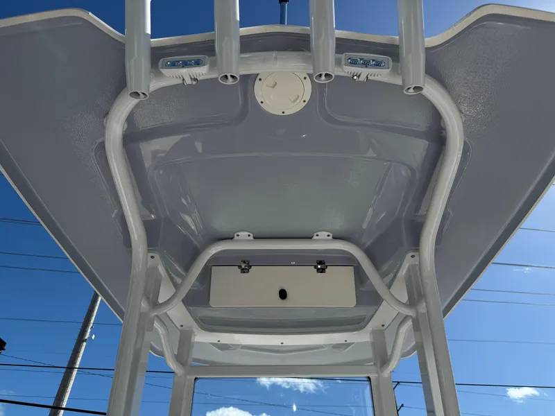 Slide: The Image of 2024 Robalo 246 Cayman boat T-top with rod holders against blue sky. - 28