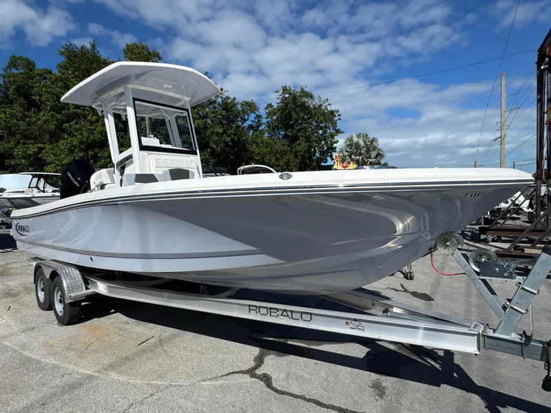 Slide: The Image of 2024 Robalo 246 Cayman boat on trailer under blue sky. - 3