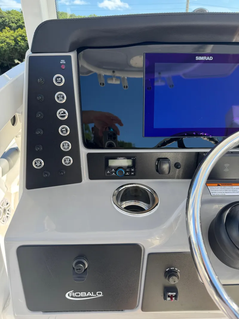 Slide: The Image of 2024 Robalo 246 Cayman boat dashboard with Simrad display and control panel. - 30