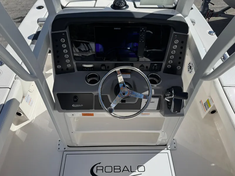 Slide: The Image of 2024 Robalo 246 Cayman boat dashboard with steering wheel and control panel. - 7