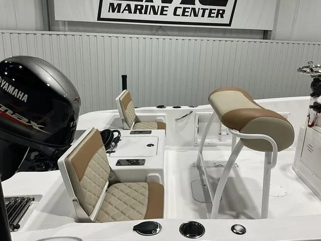 Slide: The Image of 2025 NauticStar 191 Hybrid boat interior with Yamaha engine, featuring beige seating and console. - 11