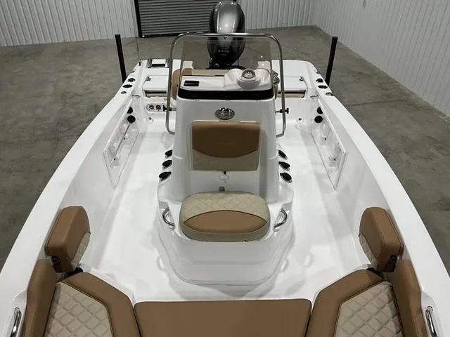 Slide: The Image of 2025 NauticStar 191 Hybrid boat interior with tan seating and modern console design. - 13