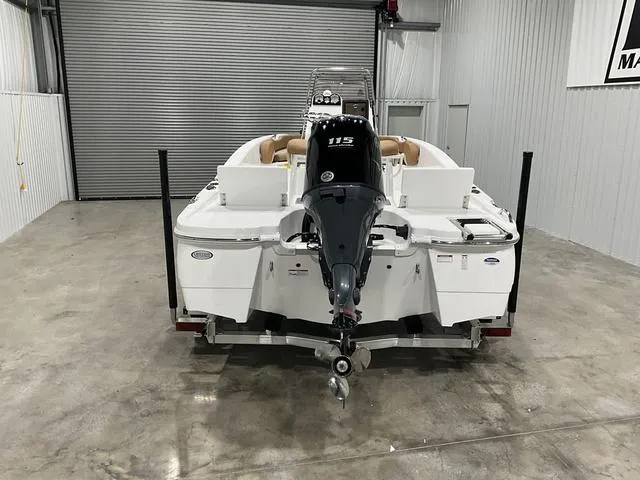 Slide: The Image of 2025 NauticStar 191 Hybrid boat with outboard motor in a garage. - 6