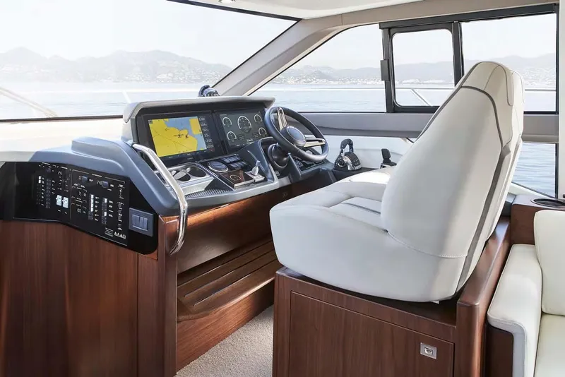 Slide: The Image of 2025 Princess 50 Flybridge yacht helm with modern navigation controls and luxurious seating. - 10