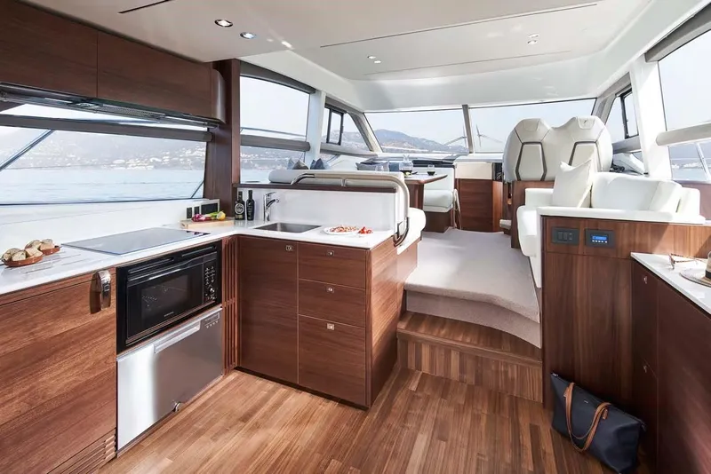 Slide: The Image of Luxurious 2025 Princess 50 Flybridge yacht interior with modern kitchen and seating area. - 15