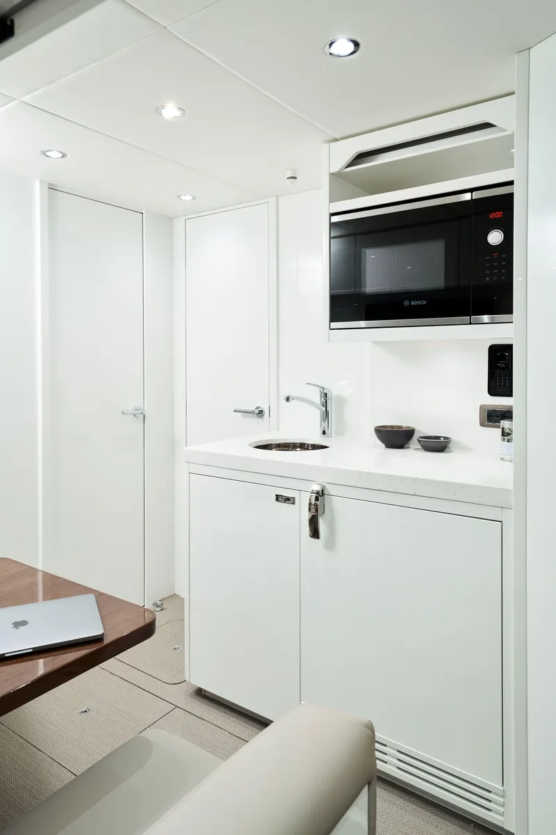 Slide: The Image of Modern kitchenette in 2025 Princess Y95 Motor Yacht with sleek white design. - 17