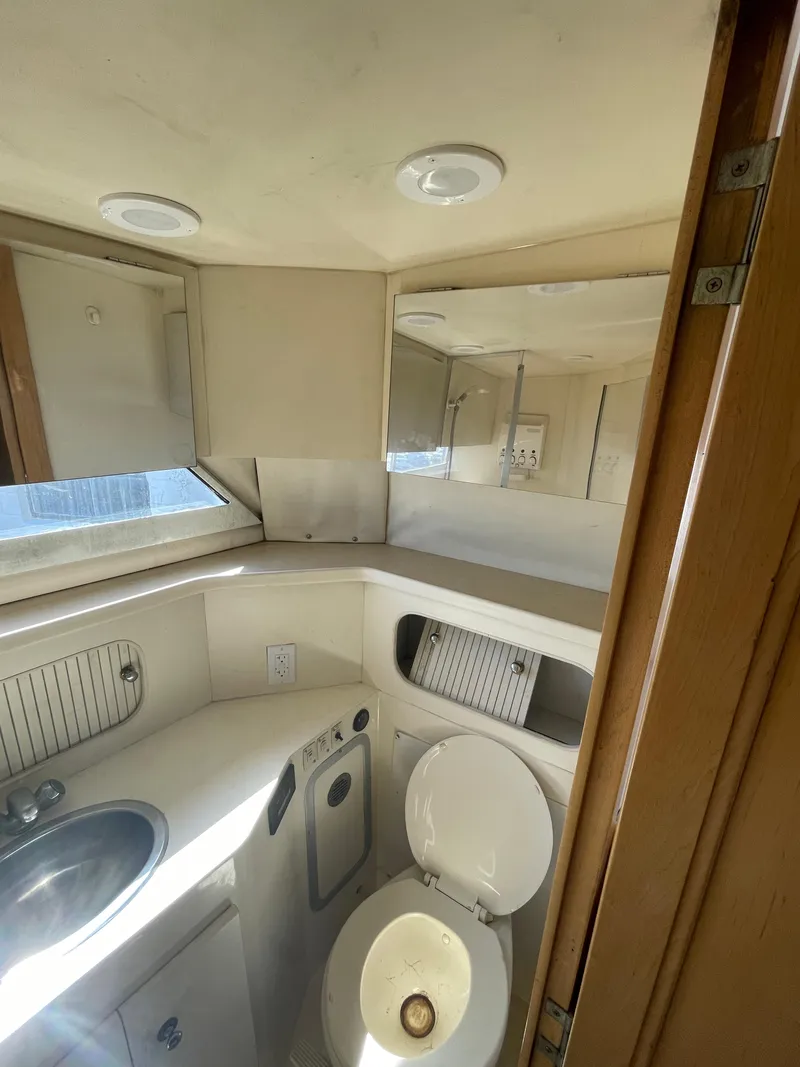 Slide: The Image of 1997 Carver 405 yacht bathroom with sink, toilet, and mirrored cabinet. - 17