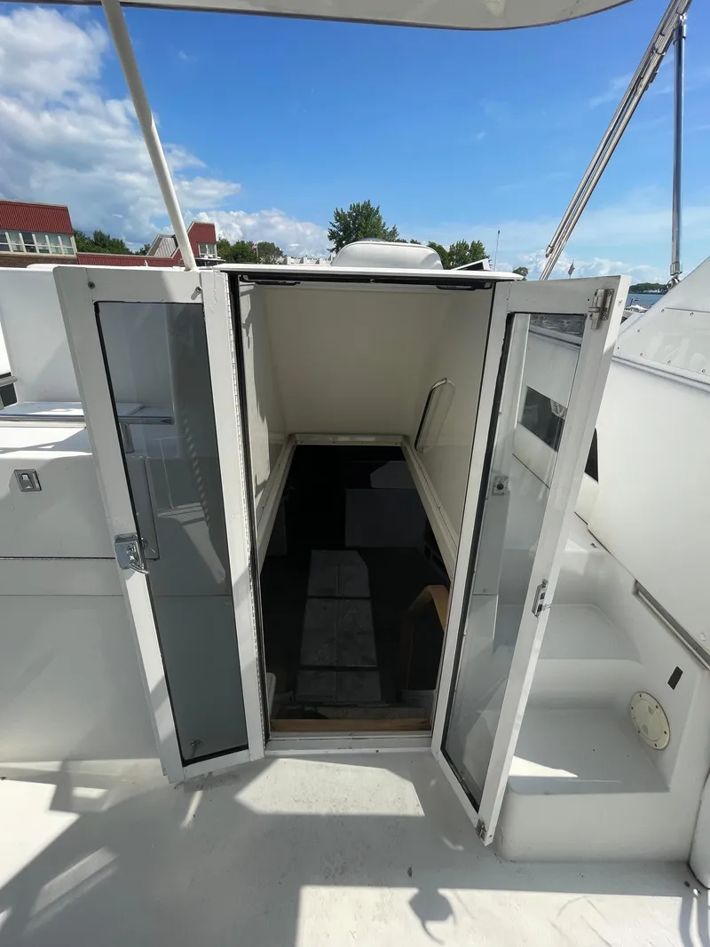 Slide: The Image of Open cabin entrance on a 1997 Carver 405 yacht under a clear blue sky. - 33