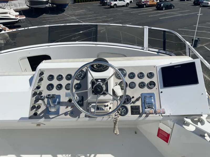 Slide: The Image of Control panel of a 1997 Carver 405 yacht with steering wheel and navigation instruments. - 37
