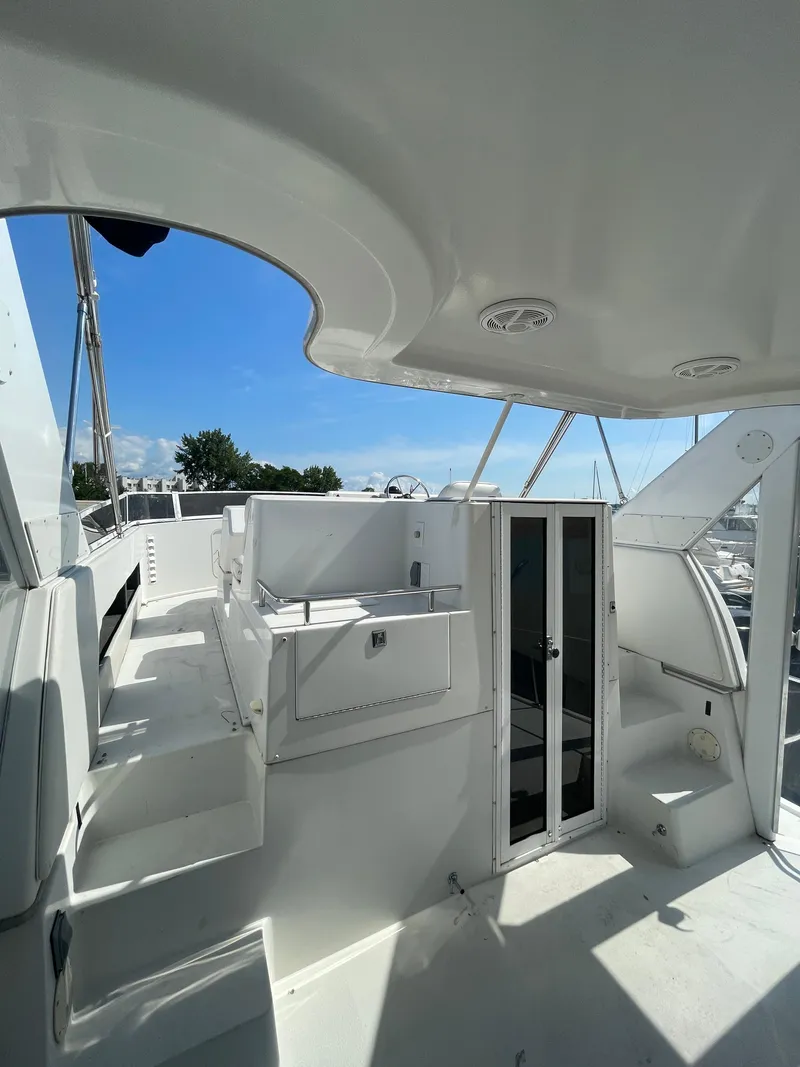 Slide: The Image of 1997 Carver 405 yacht deck with seating and clear skies. - 40