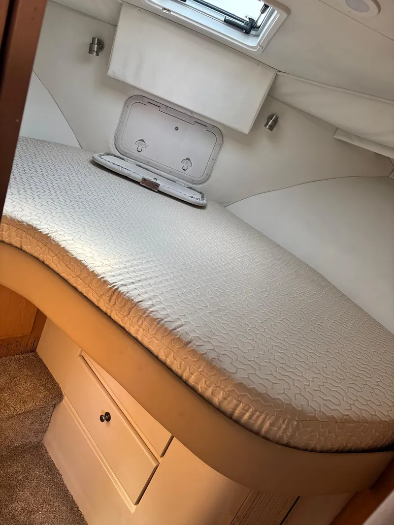 Slide: The Image of 1997 Carver 405 boat cabin with a cozy bed and storage. - 6