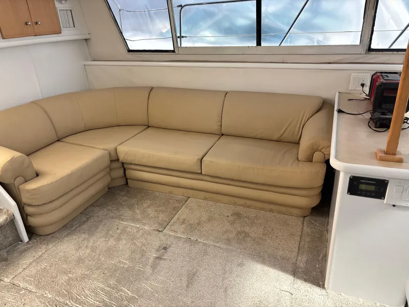 Slide: The Image of Beige leather sofa in 1997 Carver 405 yacht interior, with carpeted floor and large windows. - 8