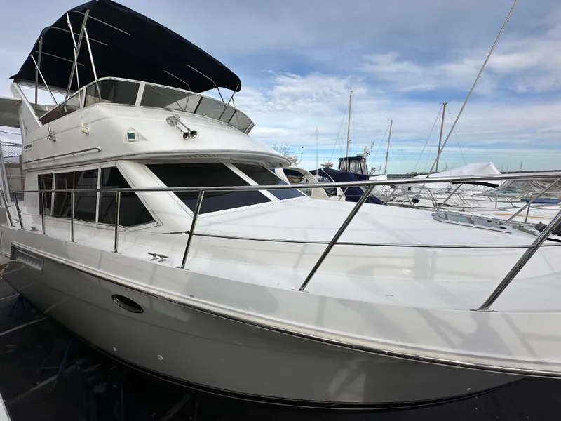 The Image of 1997 Carver 405 yacht docked at marina under blue sky. - 1
