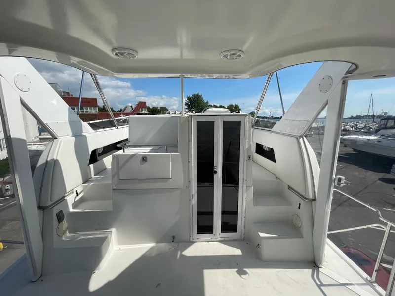 Slide: The Image of 1997 Carver 405 yacht interior with white seating and glass doors, docked at marina. - 38