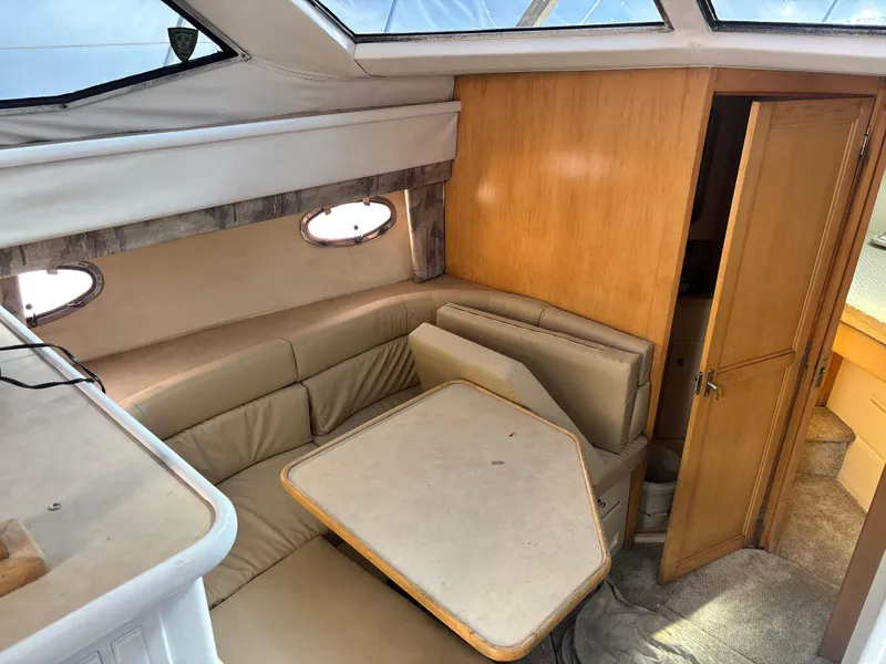 Slide: The Image of 1997 Carver 405 yacht interior with dining area and wooden cabinetry. - 5