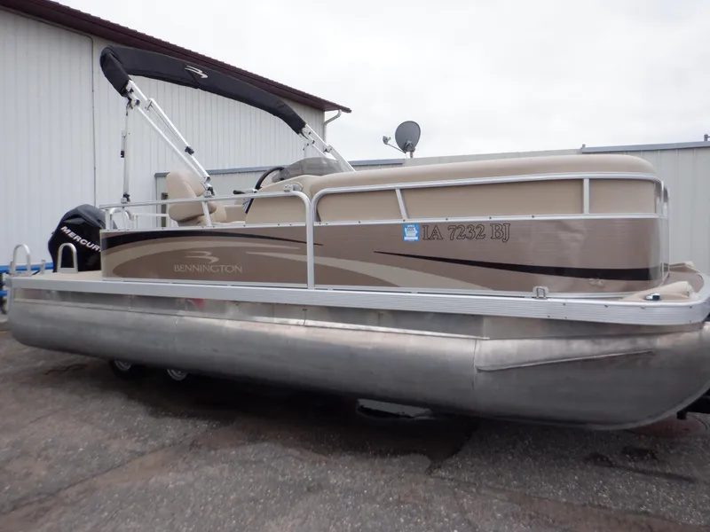 Slide: The Image of 2011 Bennington 22 SSL pontoon boat with canopy, parked outdoors. - 1