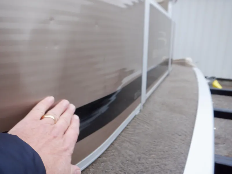 Slide: The Image of Close-up of a 2011 Bennington 22 SSL boat exterior with a hand touching the side. - 20